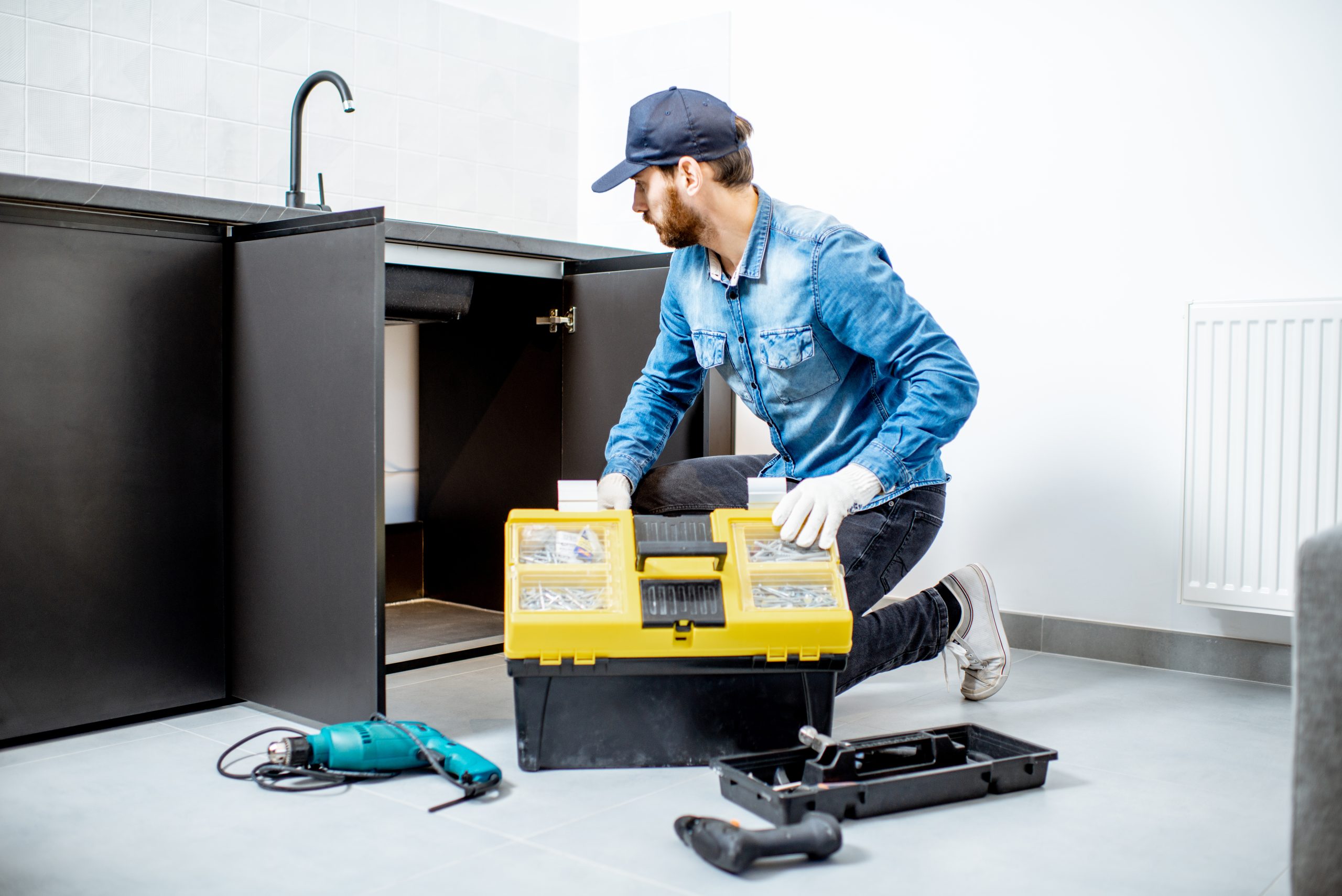 man repairing kitchen furniture