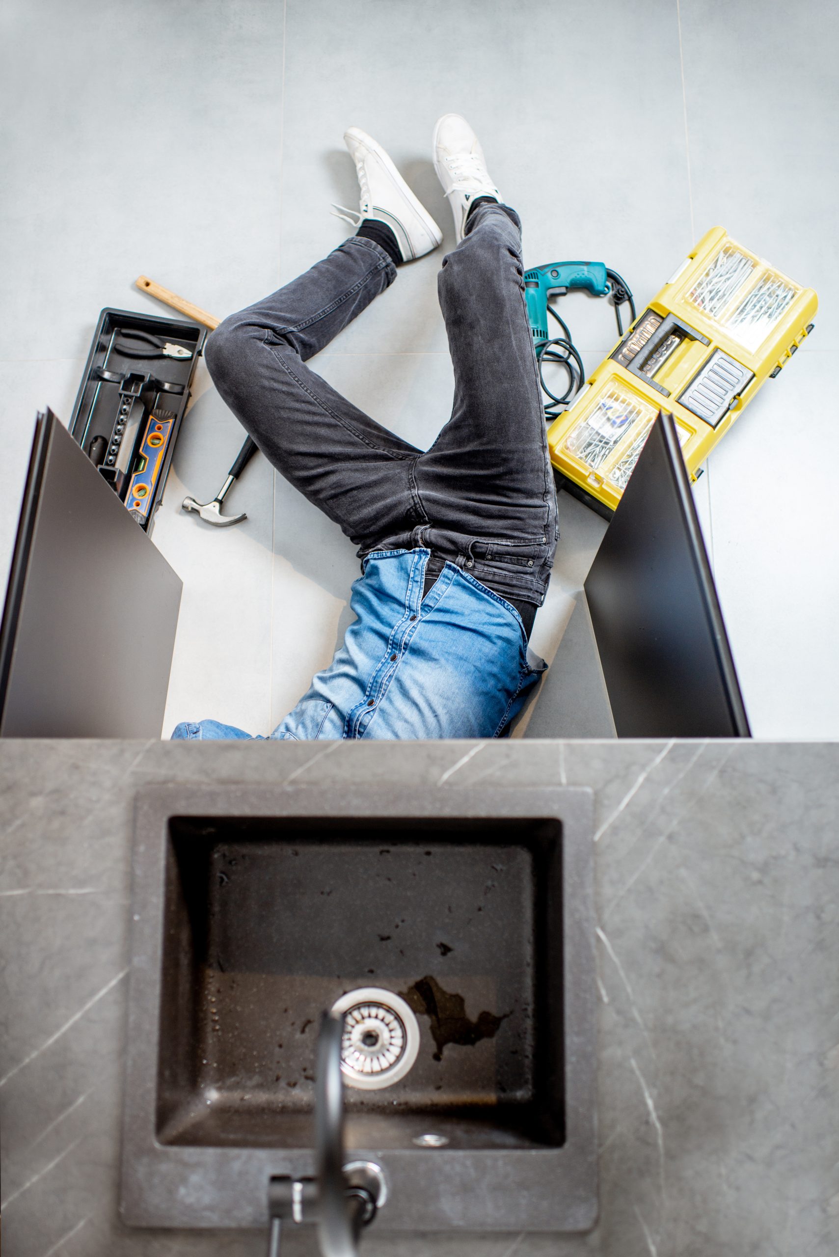 man repairing kitchen plumbing